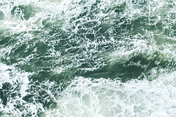 The ocean with waves. The water is a greenish colour with lots of white-caps on the waves.