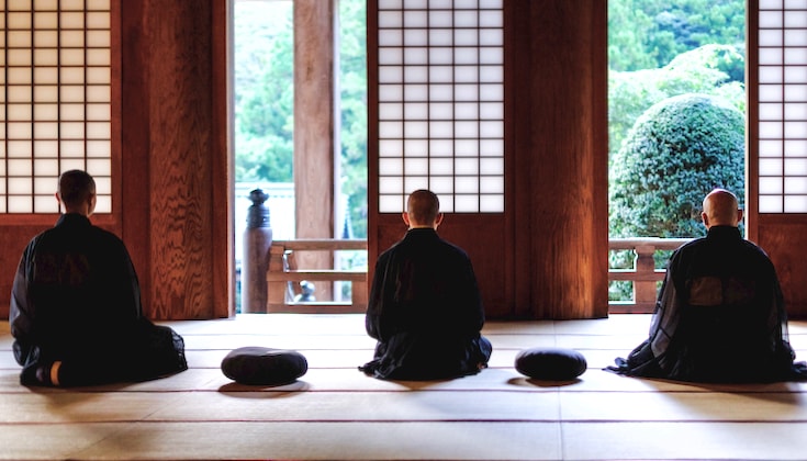 Three people meditating in a zendo.