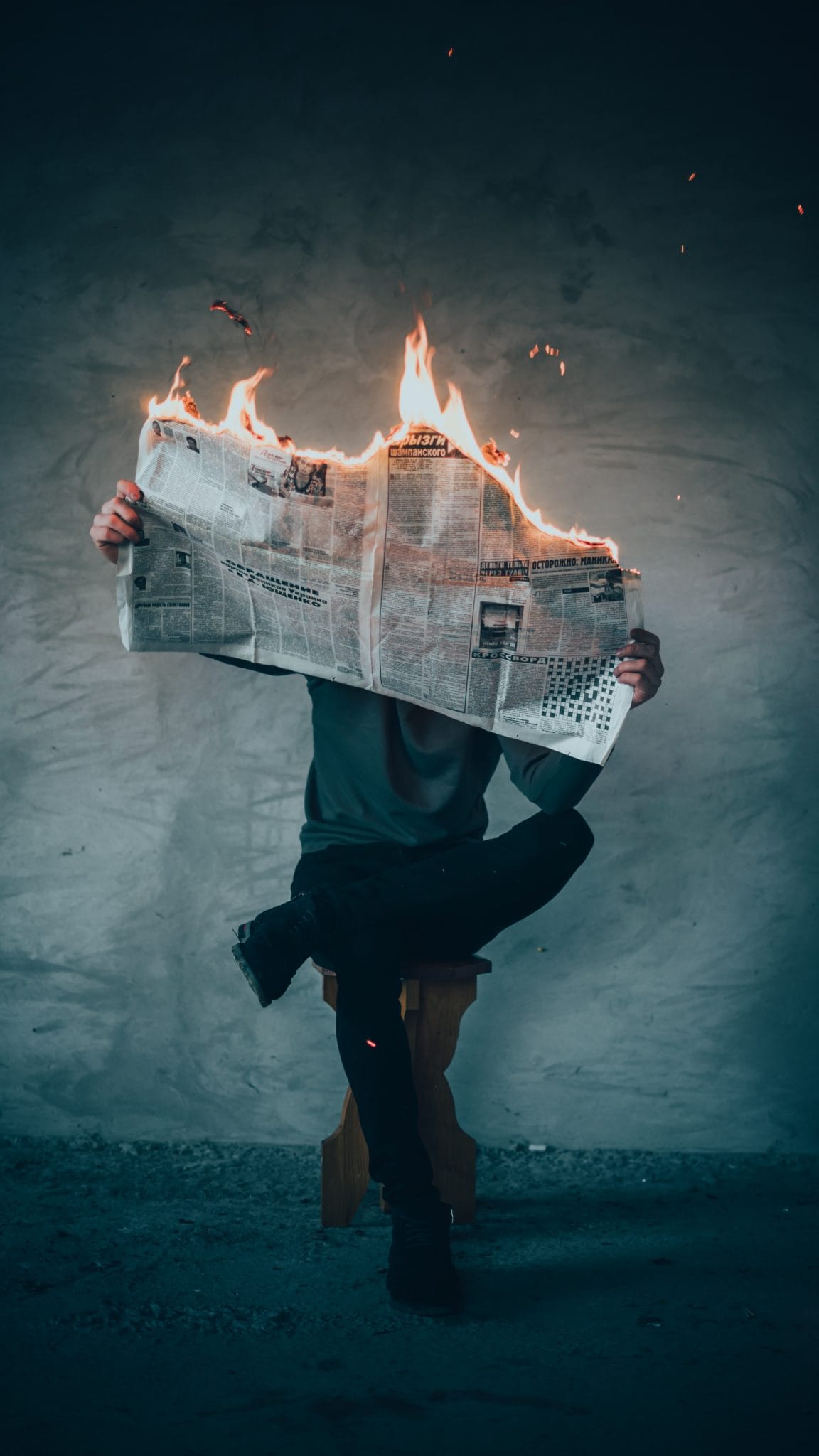 Man reading a burning newspaper.