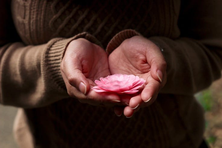 Holding a flower.