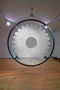 Sanford Biggers' Lotus, which is seven feet in diameter and made of steel, etched glass, and colored LEDs.