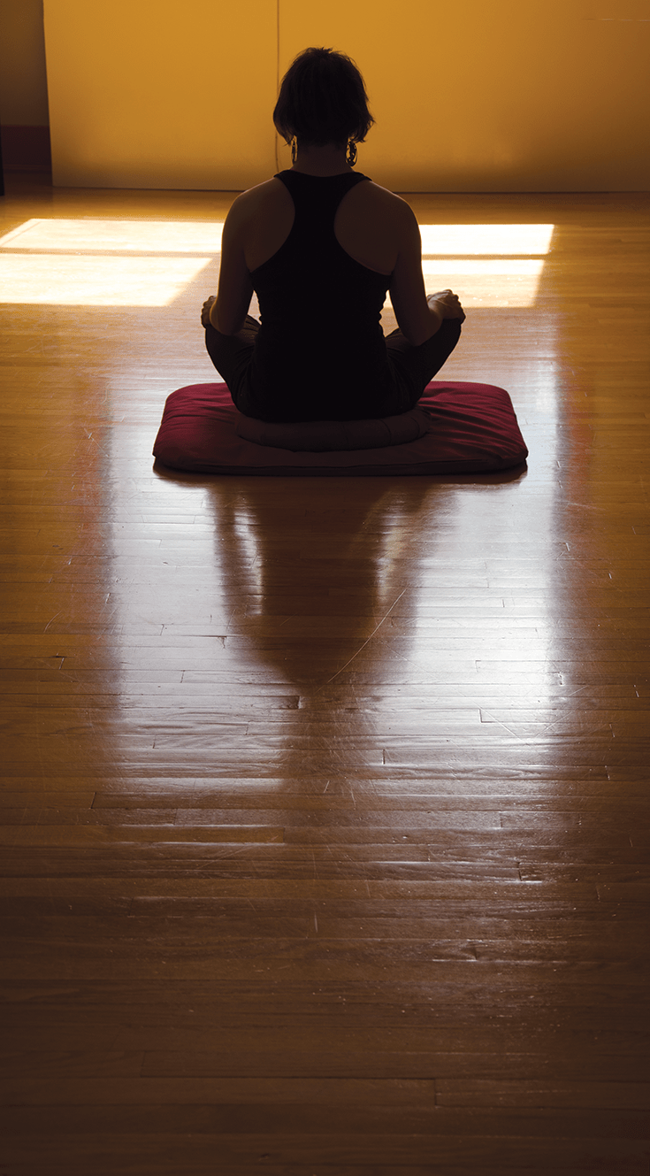 A woman sitting in meditation posture.