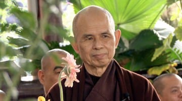 Thich Nhat Hanh holding a flower.