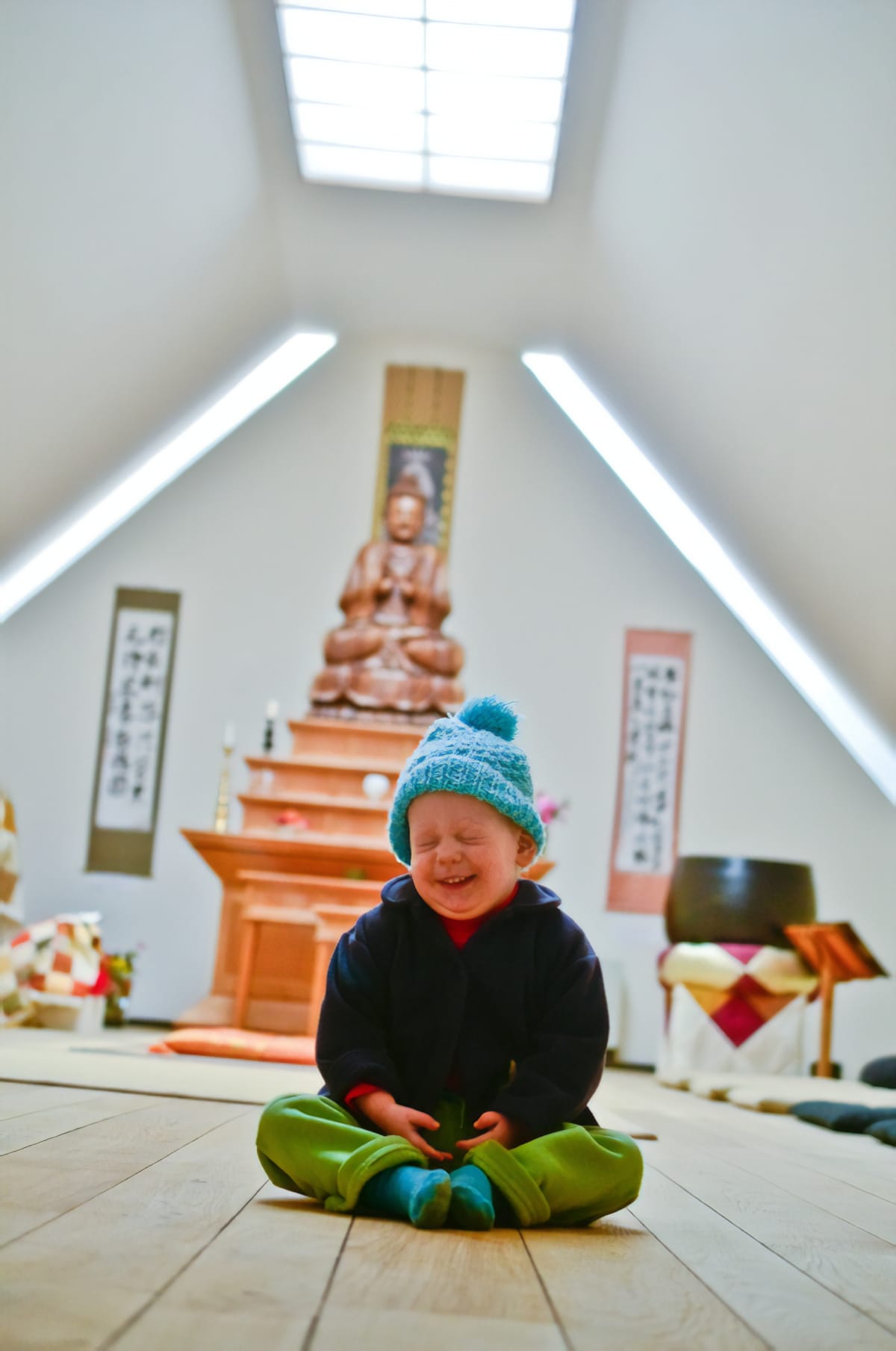 Little boy laughing in shrine room.