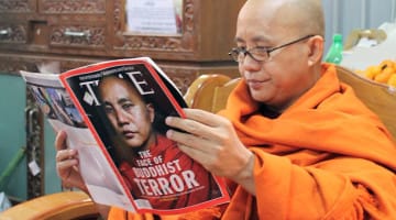 Radical Buddhist monk Ashin Wirathu reading a TIME magazine article about himself.