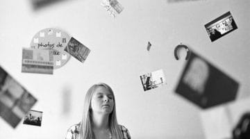 Woman sitting surrounded by pictures.