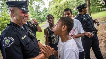 A cop laughs with children.