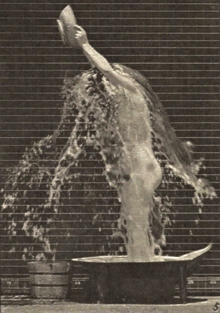 Nude woman pouring water over head.