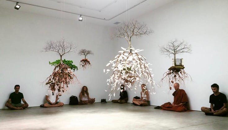 People meditating in an art gallery.