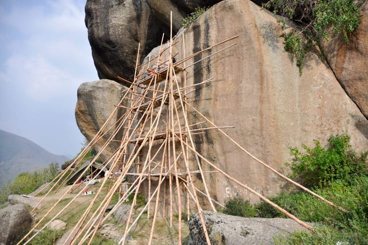 Scaffolding in front of a Buddha carved into a cliff face in Pakistan.