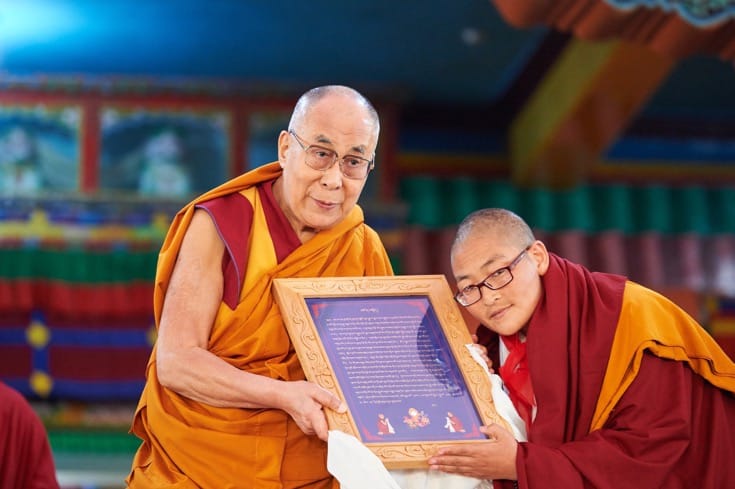 Nun presented framed text to the Dalai Lama.