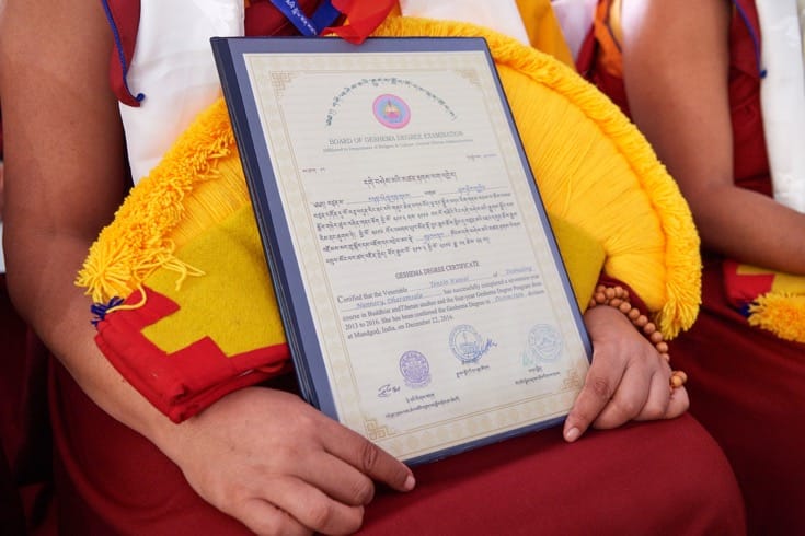 A nun holding her Geshema certificate.