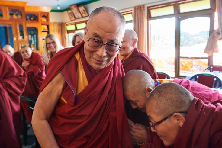 Nuns bowing before the Dalai Lama.