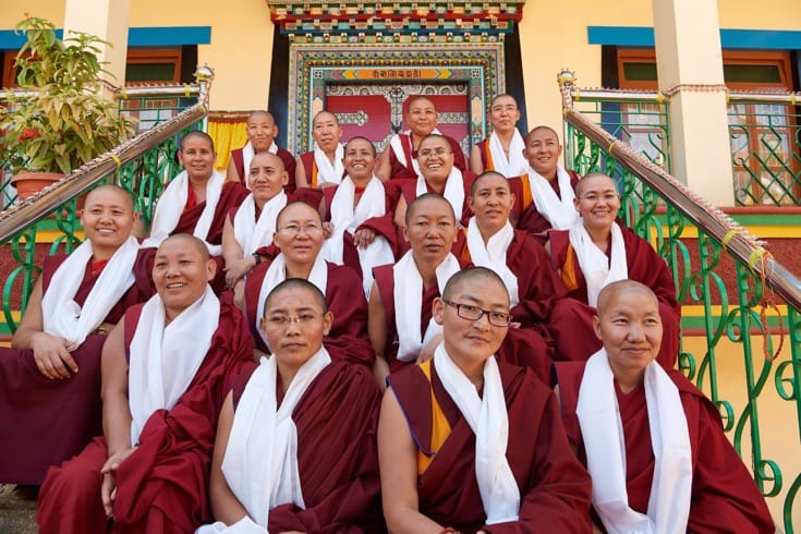 Eighteen nuns sitting on steps.