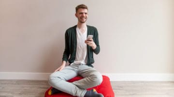 Meditator holding an iPhone.