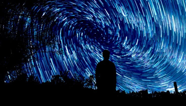 A person against the background of Van Goghs starry night.