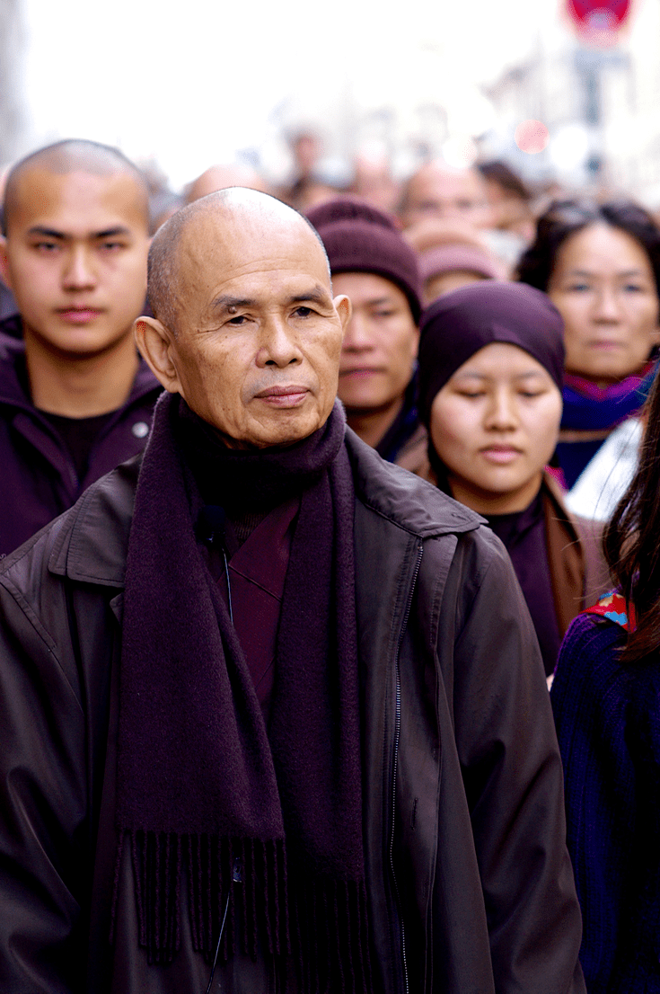 Thich Nhat Hanh walking with a crowd.