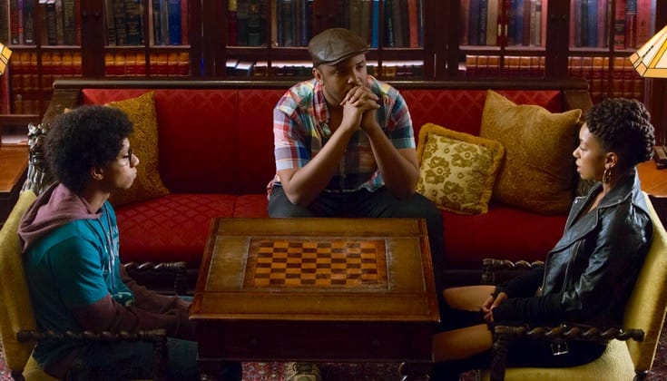 Justin Simien sitting on a couch talking to actors on the set of "Dear White People."