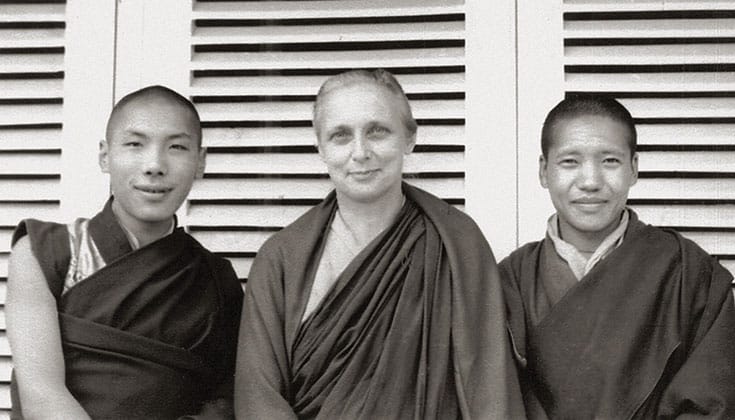 Three people all dressed in Monks robes.