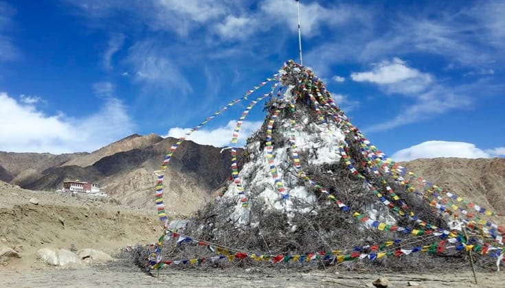 A melting stupa decorated with prayer flags.