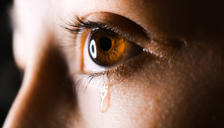 A close up of an eye crying.