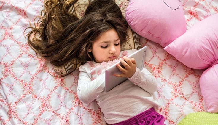 Young girl looks at tablet