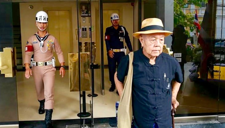 Sulak Sivaraksa standing outside of a building.