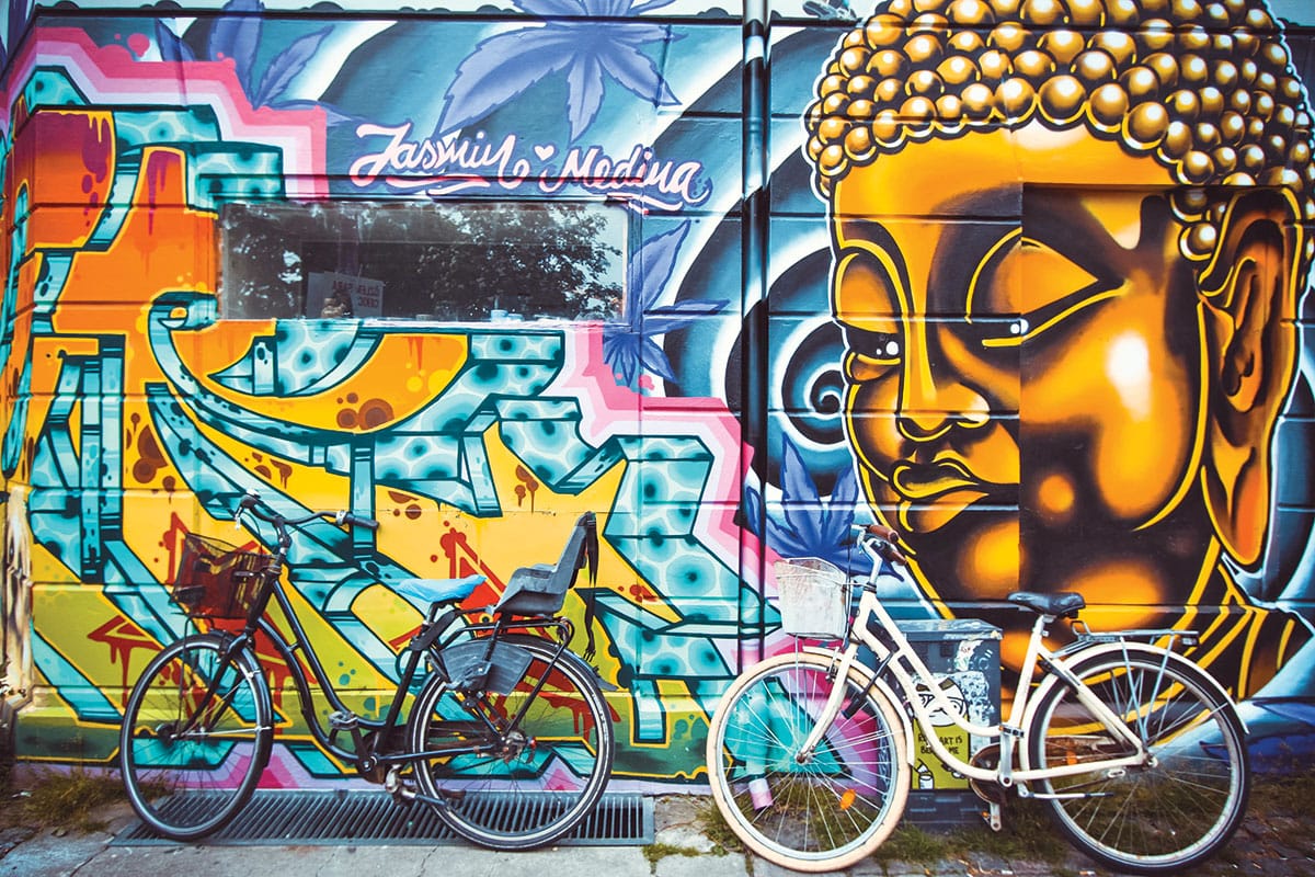 Bicycles in front of mural with Buddha