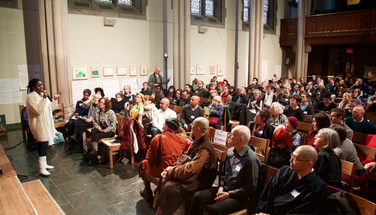 Beatrice Anderson talking to an audience of Buddhists.
