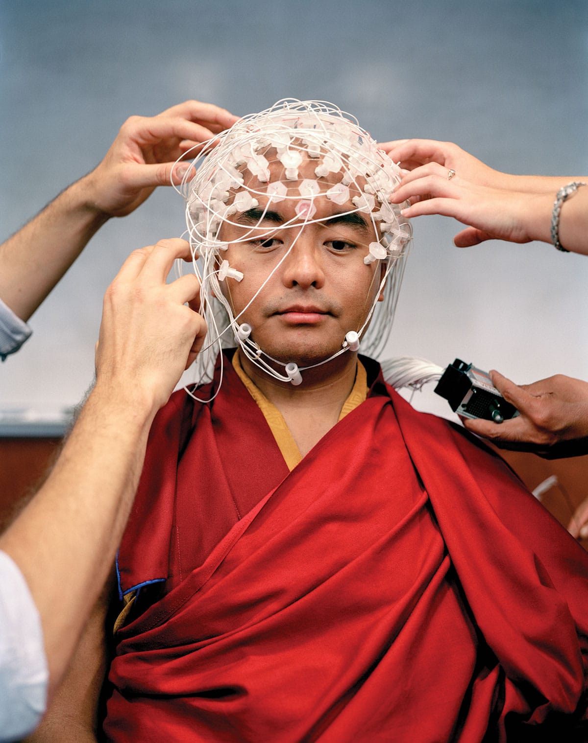 Yongey Mingyur Rinpoche is fitted with 256 thin wires to measure his brain waves while he meditates.