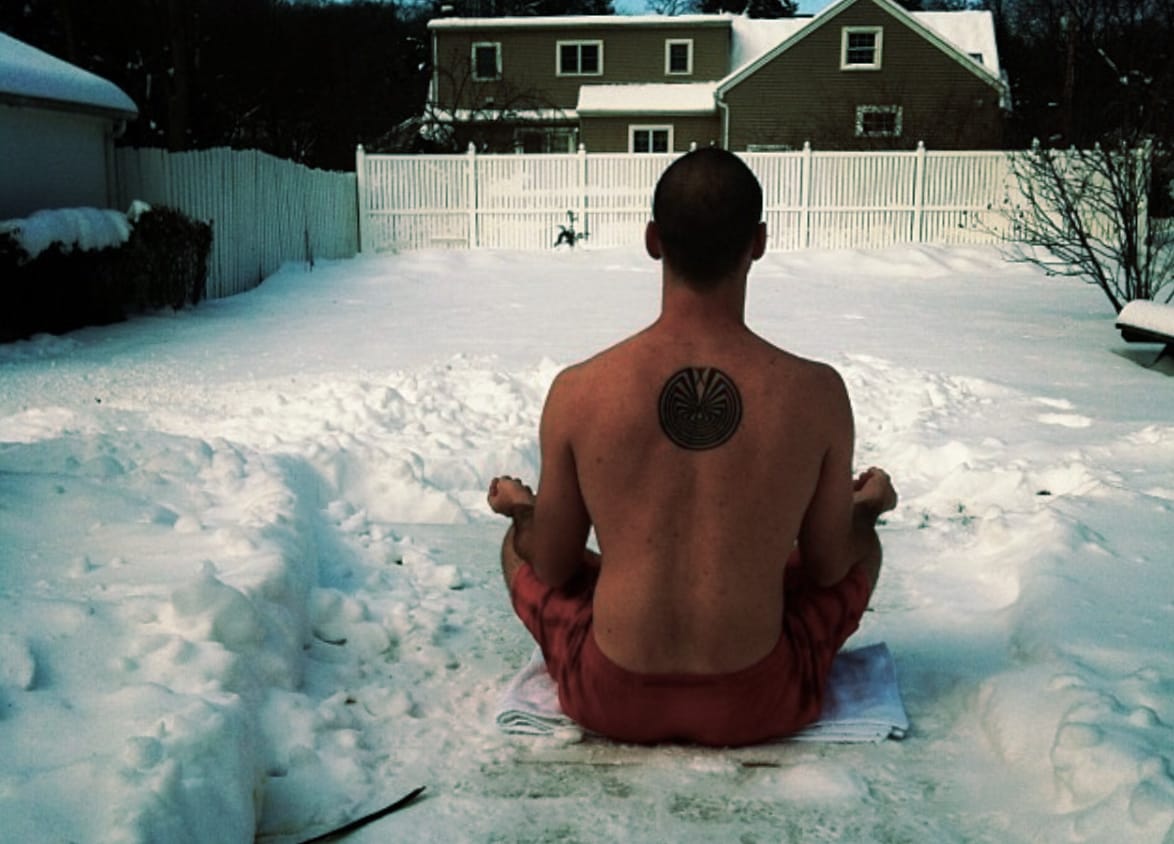 Man sitting in meditation in the snow.
