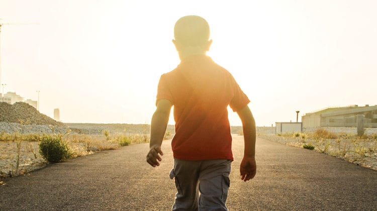 Boy walking into the light.