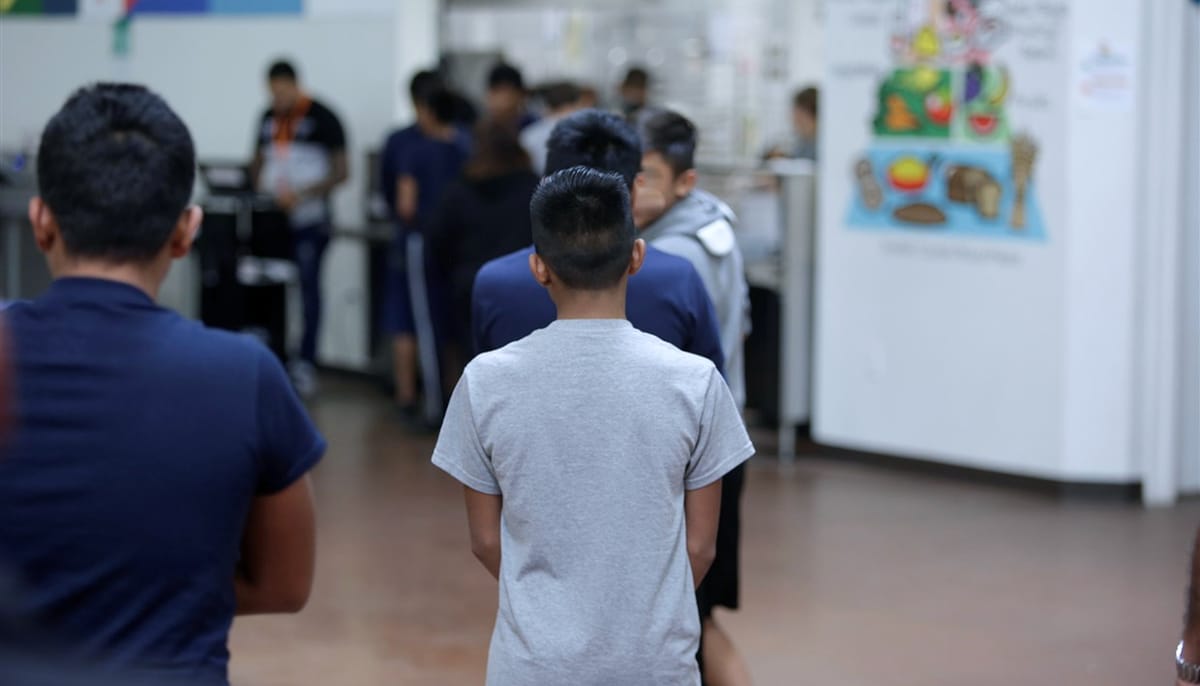 Boy stands in line in a detention center.