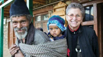 Man with baby on his back, with Roshi Joan Halifax.