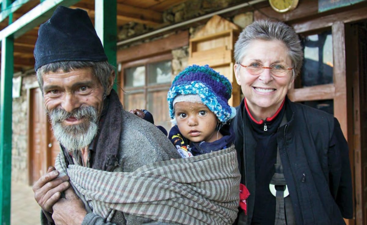 Man with baby on his back, with Roshi Joan Halifax.