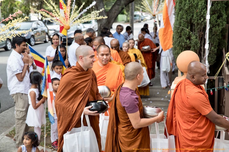 Monks in orange robes walking on alms rounds in Los Angeles.