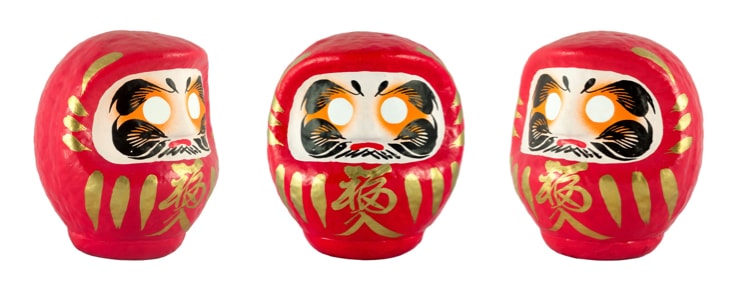 A japanese Daruma doll seen from left, front, and right.