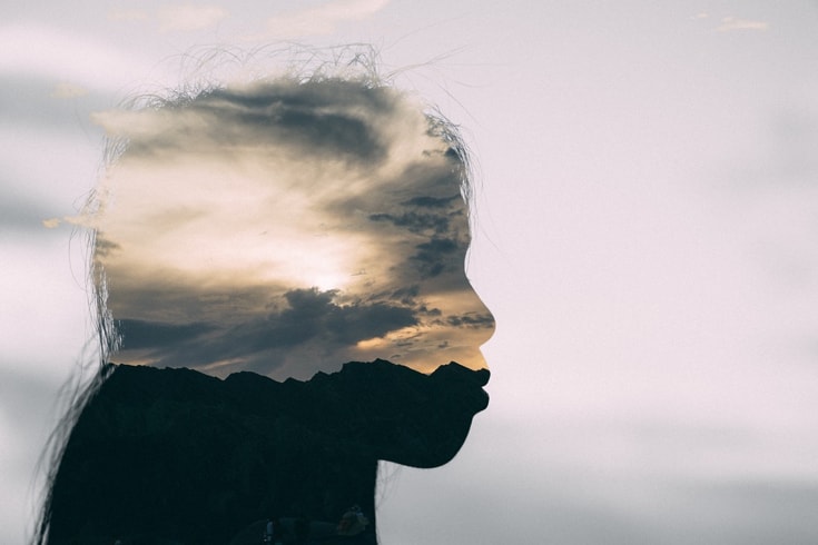 Double exposure of a person and a landscape