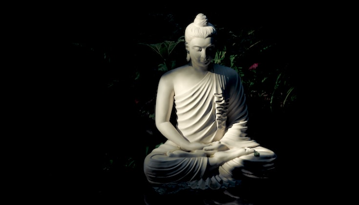 Buddha statue in shadows.