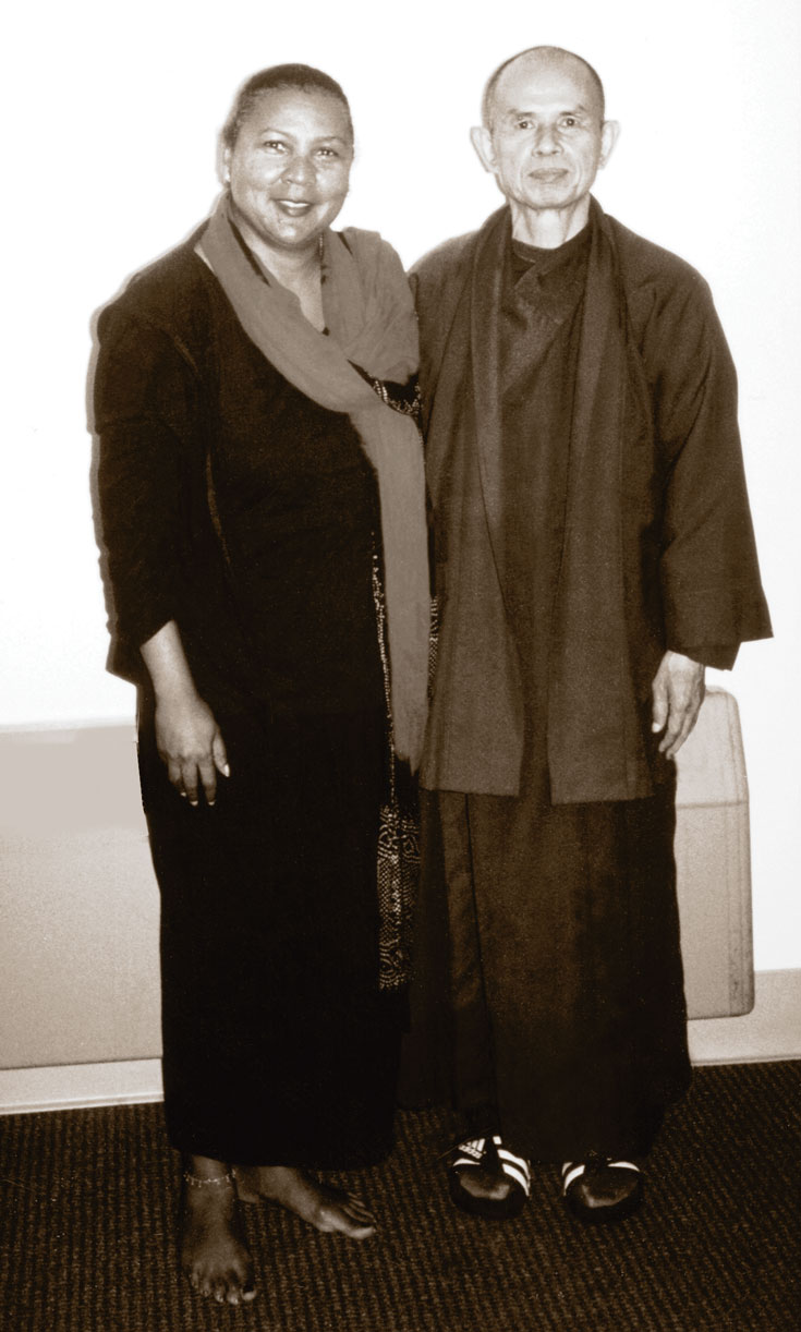 A black and white photo of a man and a woman. The woman is wearing dress clothes with a scarf, and the man is wearing loose fitting clothes and a scarf.
