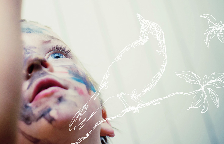 A child with paint on it's face. The child is looking up and has blue eyes. There is a white line drawing of a bird overlayed on the photo.