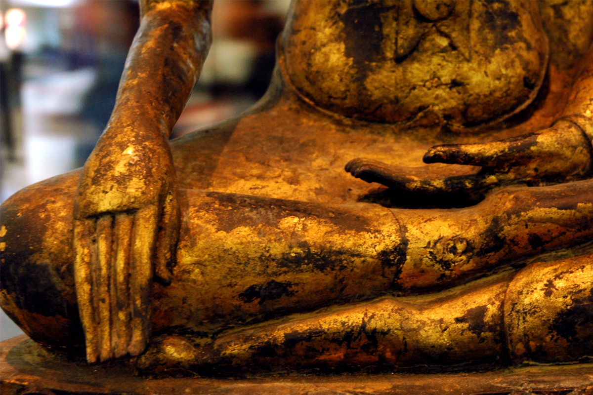 A close up of a hand on a gold statue.