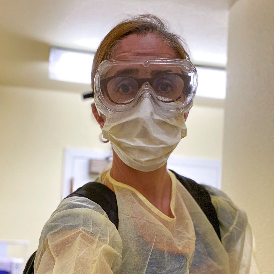 Joanne wearing personal protective equipment including mask, safety glasses, and scrubs