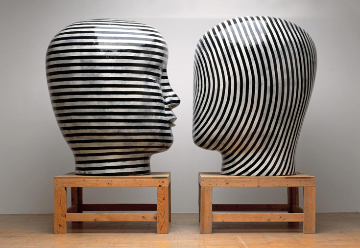 Two black and white heads on wooden platforms.