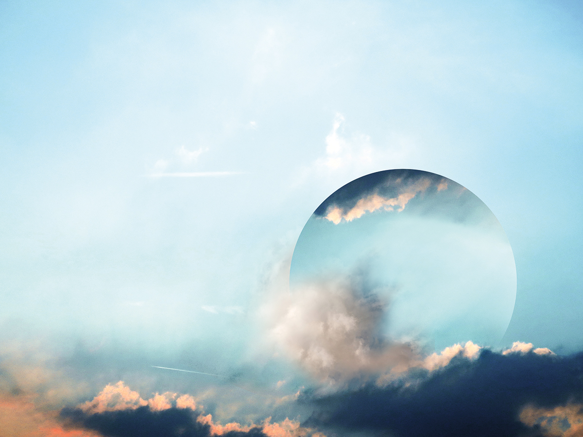 A circle with clouds in it over a blue sky.
