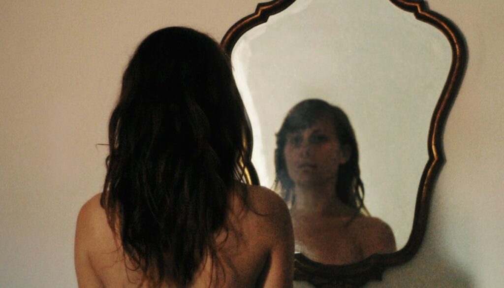 Woman looking in mirror.