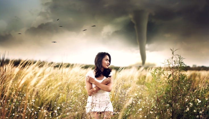 Women standing in front of a tornado.