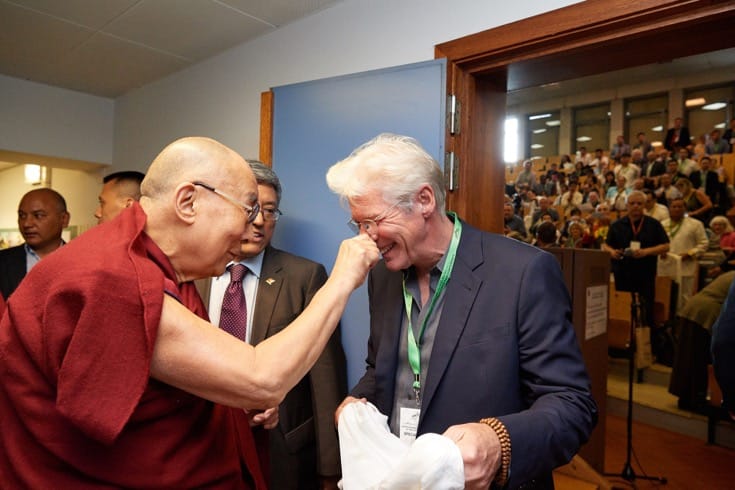 The Dalai Lama squeezes Richard Gere's nose.