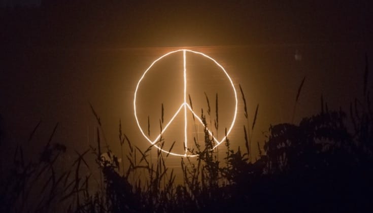 Peace sign written in light at night.