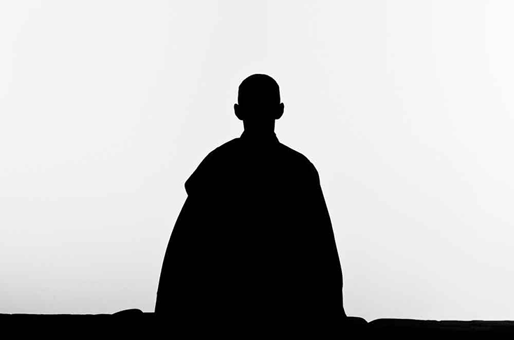 A silhouette of a person meditating.